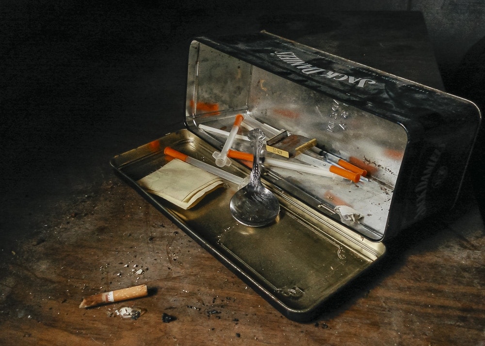 A junky's heroin kit in a Jack Daniels tin at an abandoned house in East Texas
