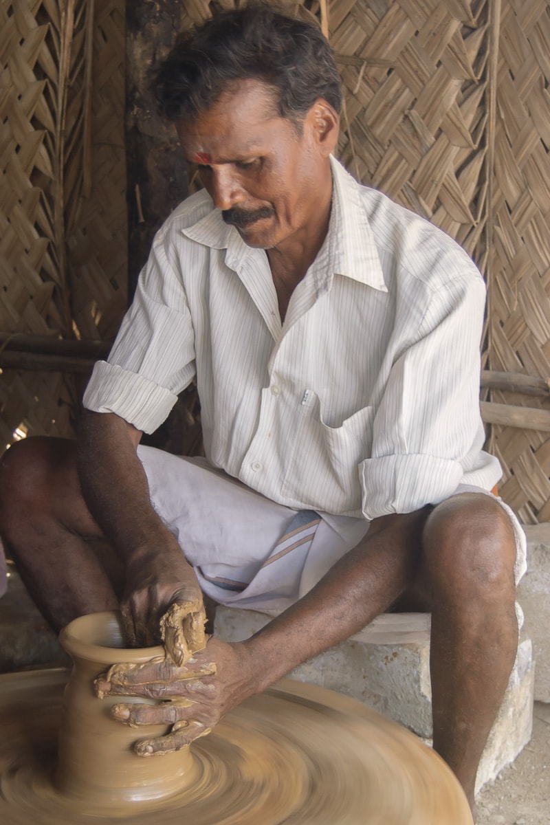 A man making a jar out of clay