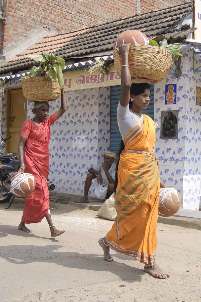 two women carrying baskets on their heads