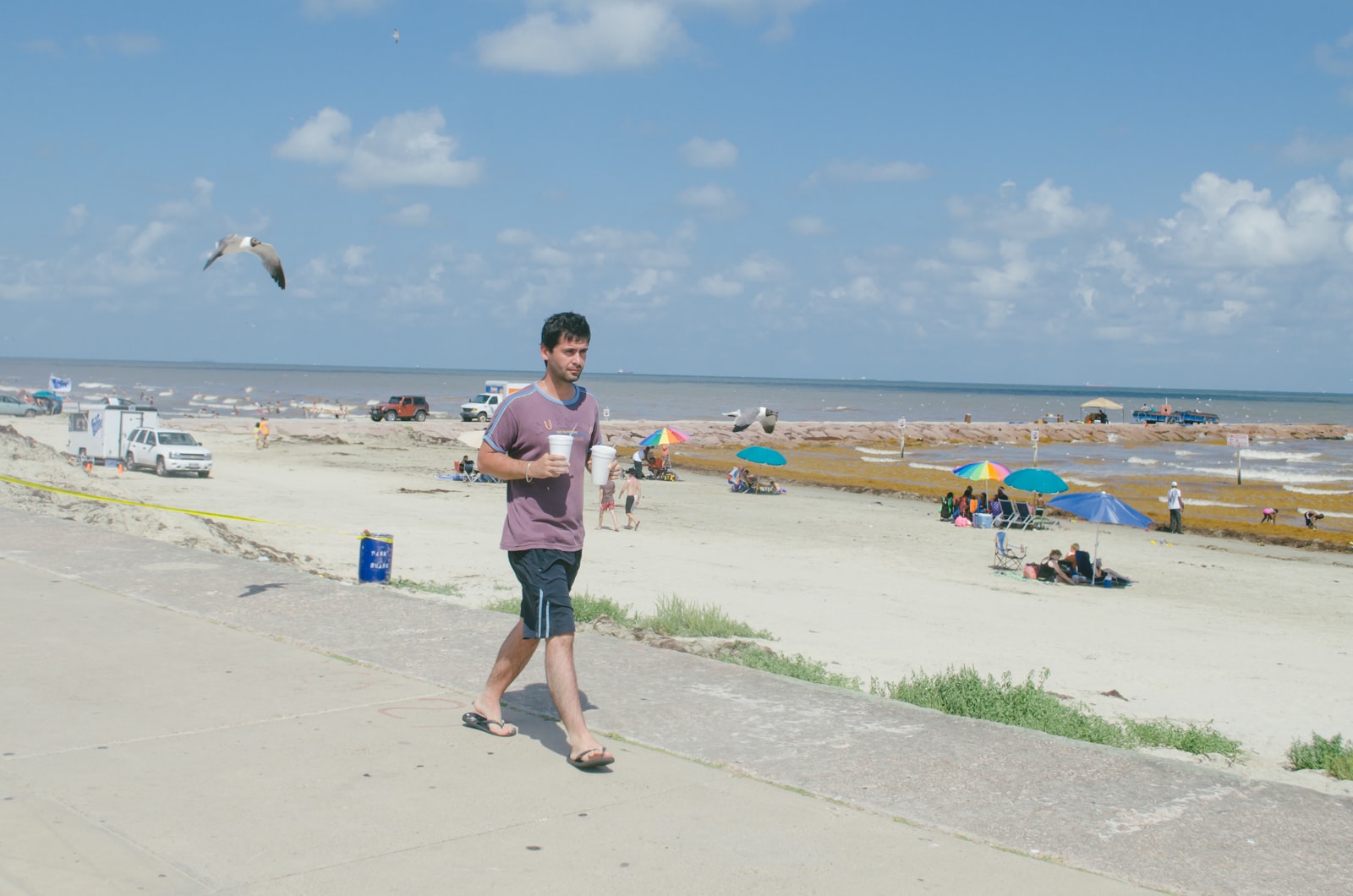 A guy walking along the beach