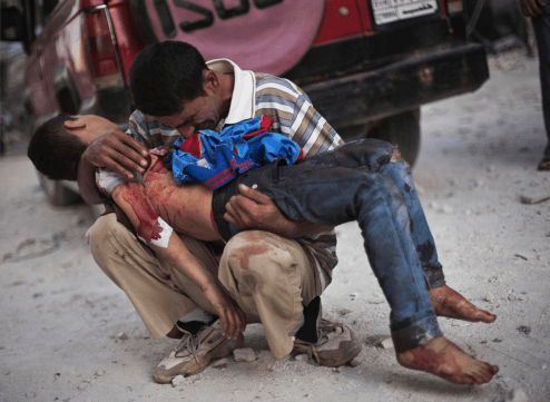 A Syrian man cries while holding the body of his son near Dar El Shifa hospital in Aleppo, Syria, Oct. 3, 2012. The boy was killed by the Syrian army. (Manu Brabo, Associated Press - October 3, 2012)