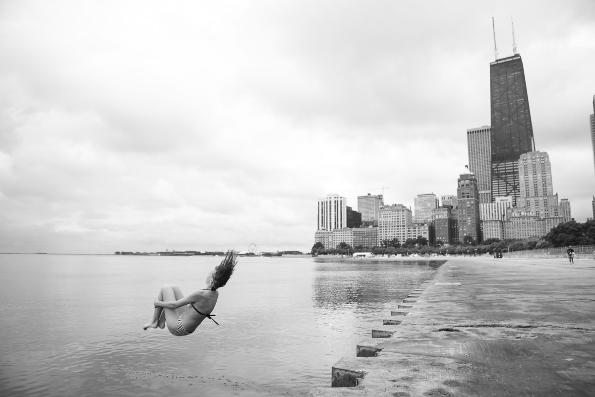 A woman jumping into Lake Michigan by Chicago Beach