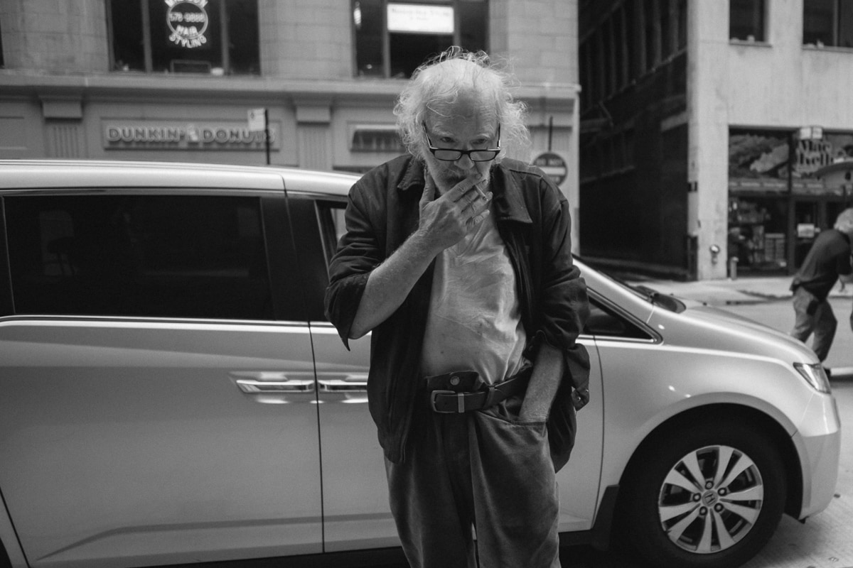 An old man smoking on the street in Chicago
