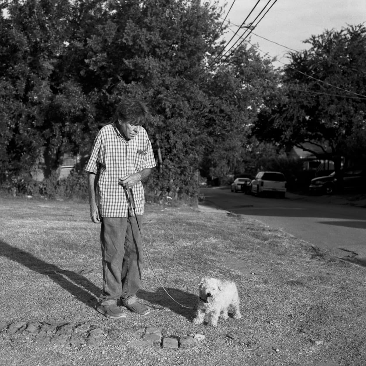 A man walking his dog outside of his home in Old East Dallas