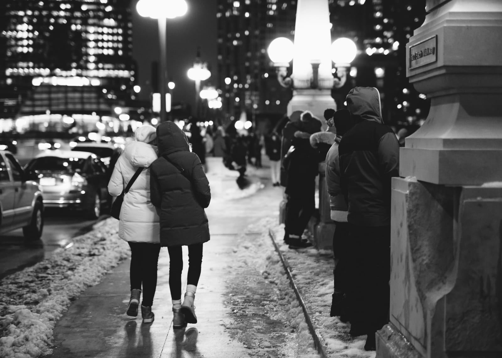 Two women walking on a snowy sidewalk in Chicago