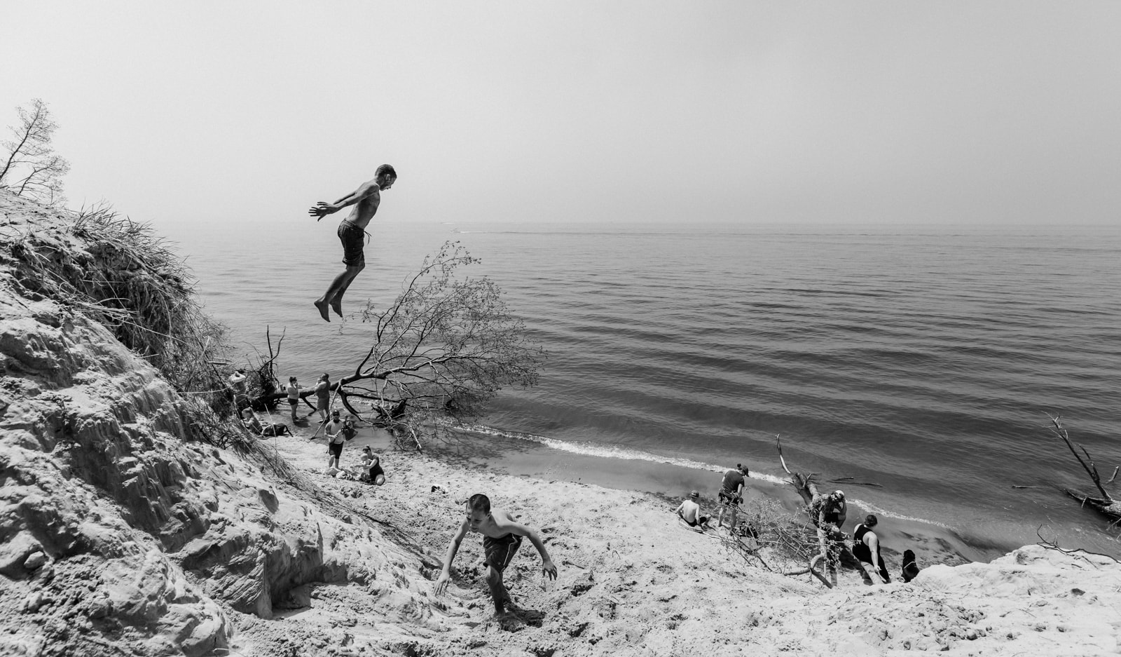 A boy jumping off of a sand dune at Lake Michigan beach in Holland, Michigan