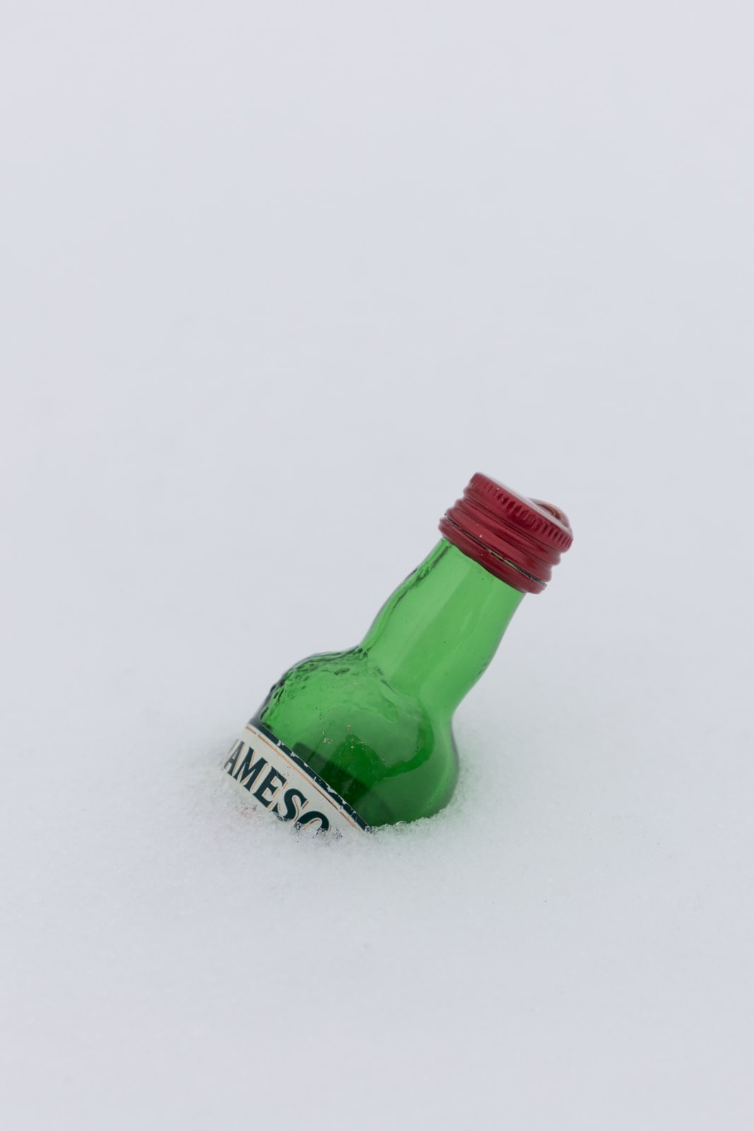 A miniature bottle of Jameson Whisky in the snow