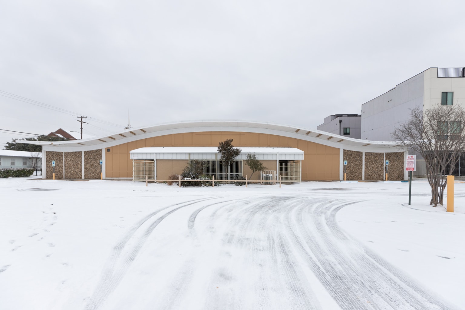 An abandoned mid century grocery story on a snowy day in Dallas