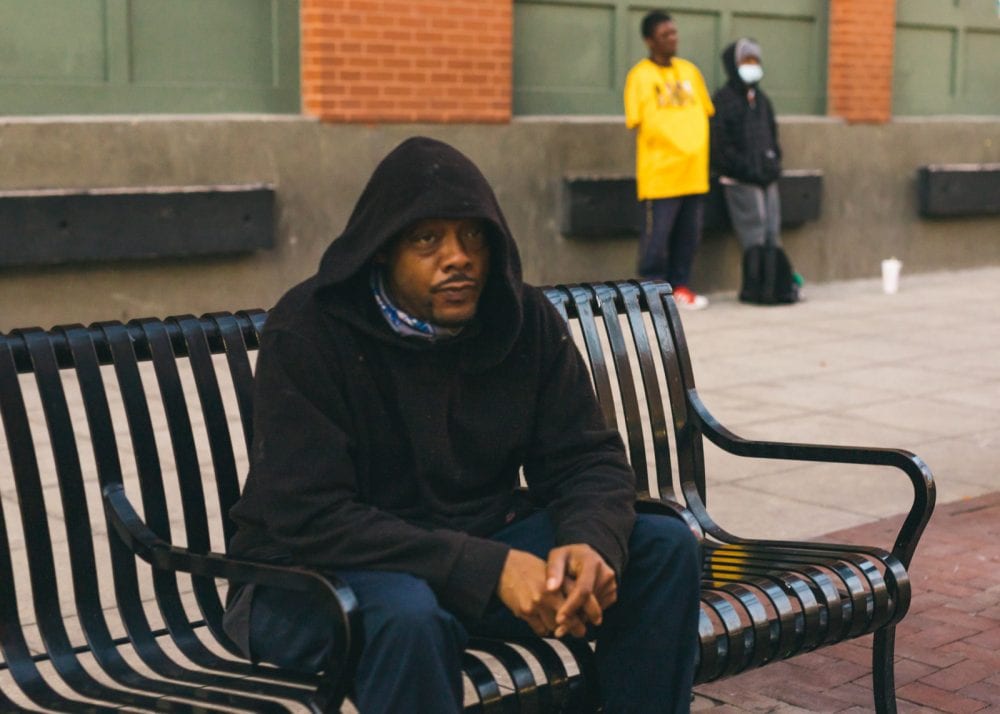 Man sitting on bench at a train station in Dallas