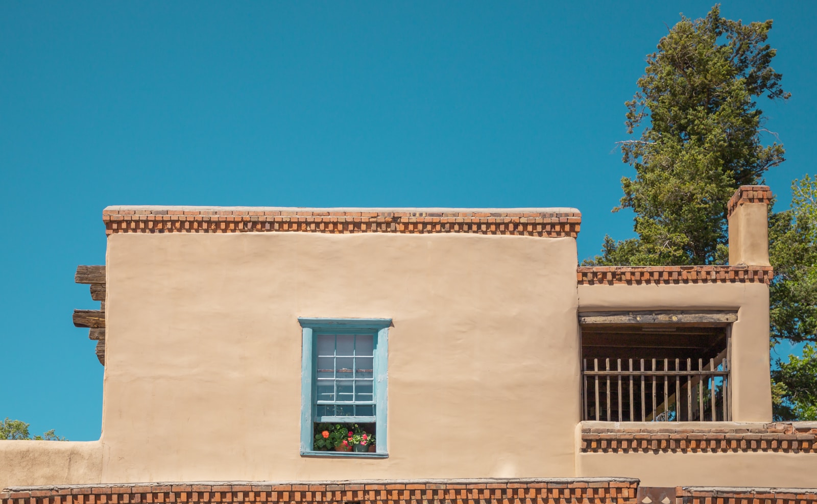 Flowers in the window of a Pueblo Revival style home