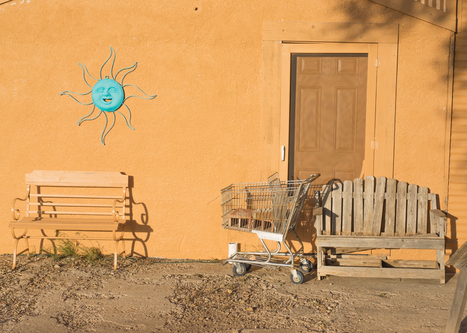A bench, shopping cart, and blue sun in Adrian, Texas