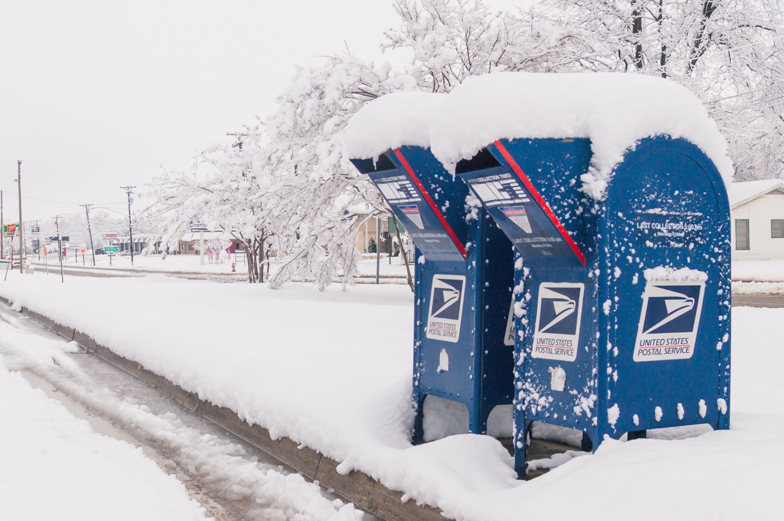 Blue mailboxes covered with snow