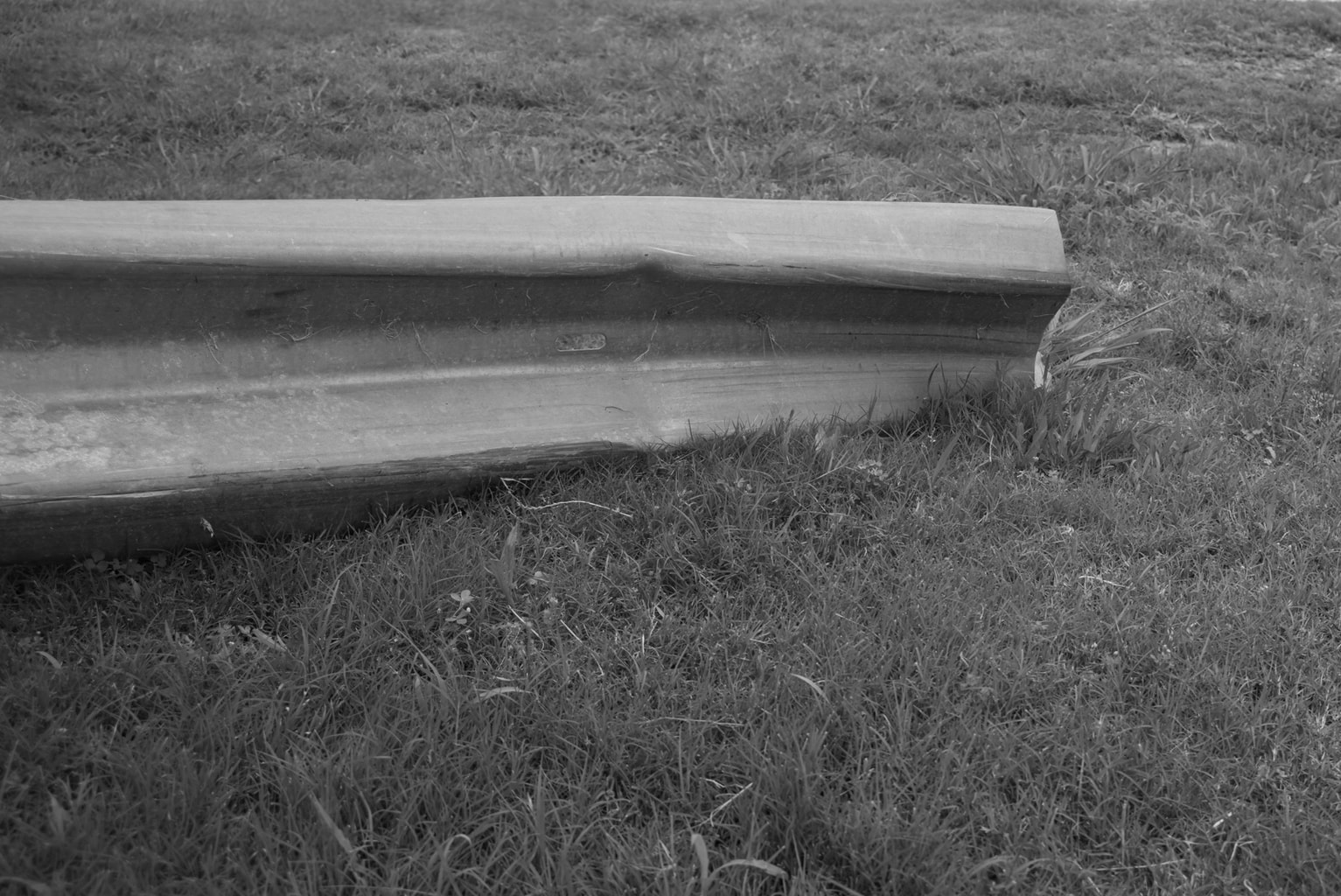 A guardrail sitting in the grass