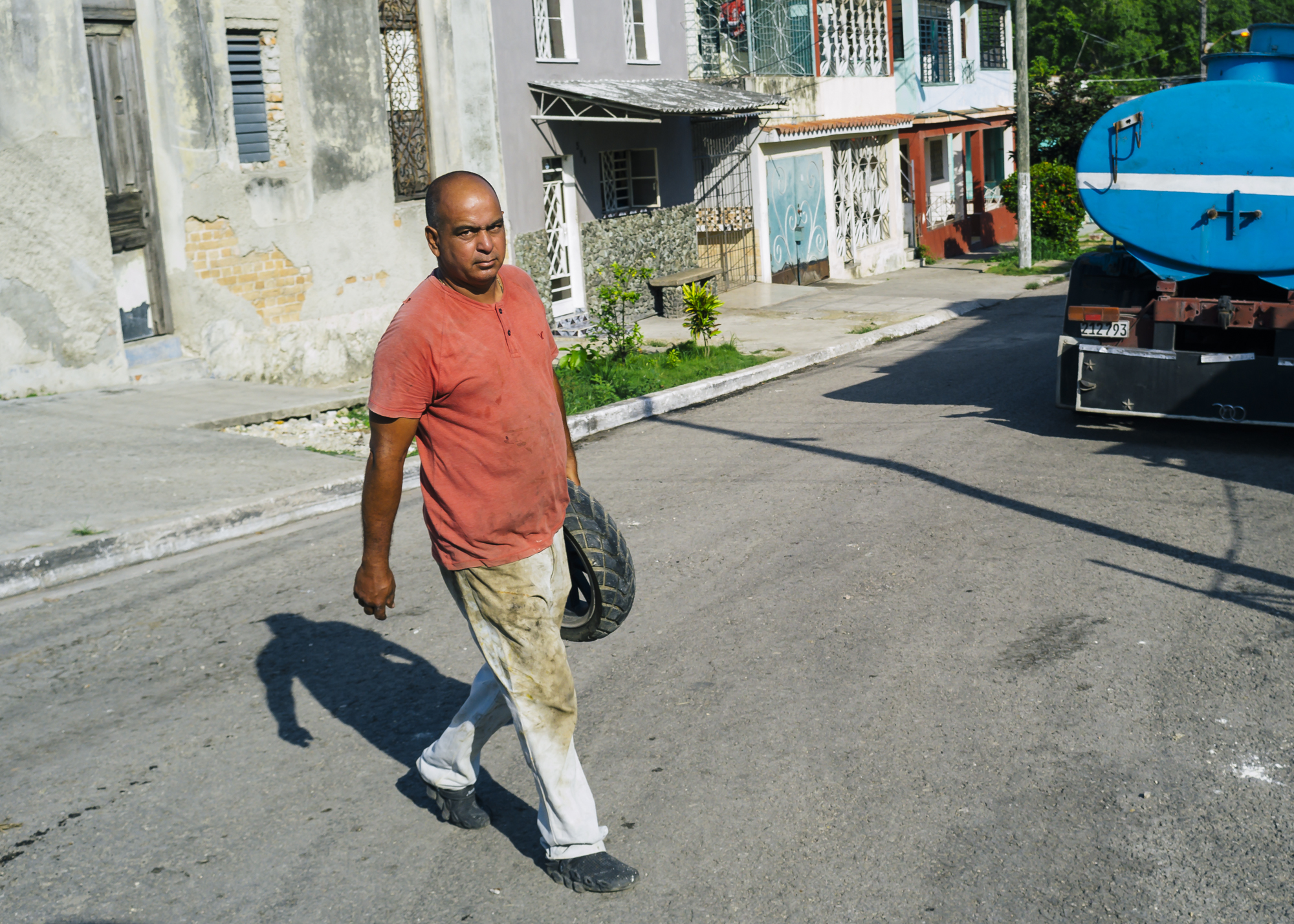A man carrying a car tire